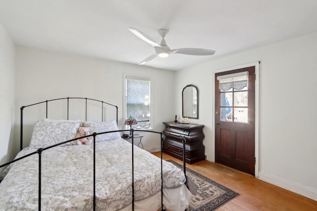 bedroom with baseboards, wood finished floors, and a ceiling fan