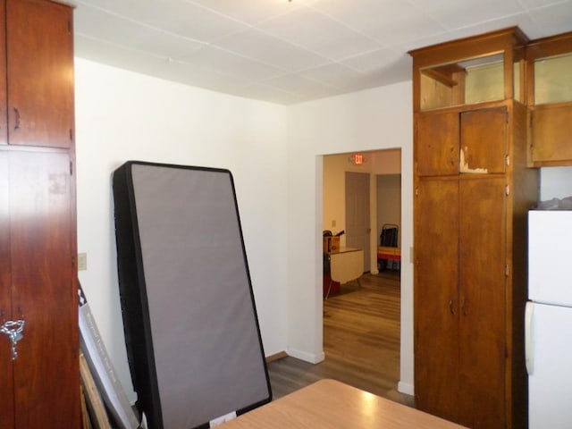 kitchen with white refrigerator and dark wood-type flooring