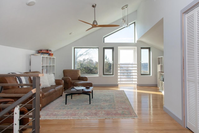 living area with ceiling fan, lofted ceiling, and light hardwood / wood-style flooring