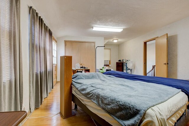 bedroom featuring light hardwood / wood-style floors and a textured ceiling