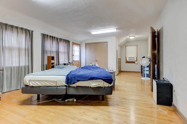 bedroom featuring light hardwood / wood-style floors and a textured ceiling