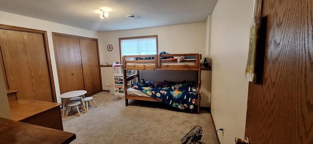 bedroom featuring two closets and light carpet