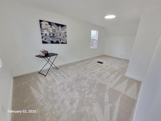 additional living space with vaulted ceiling and carpet