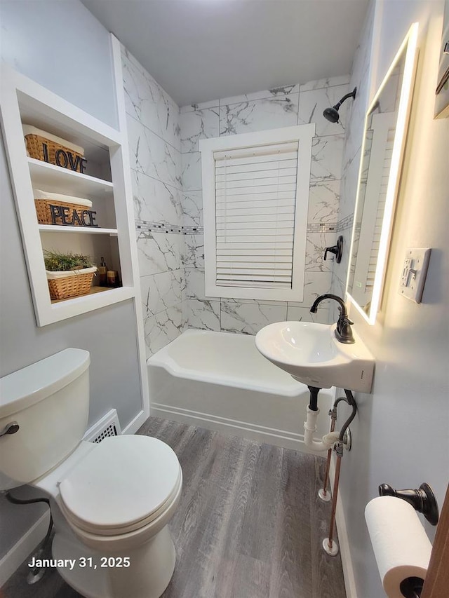 full bathroom featuring hardwood / wood-style flooring, tiled shower / bath, sink, and toilet