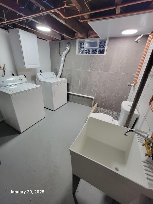 clothes washing area featuring sink and washing machine and dryer