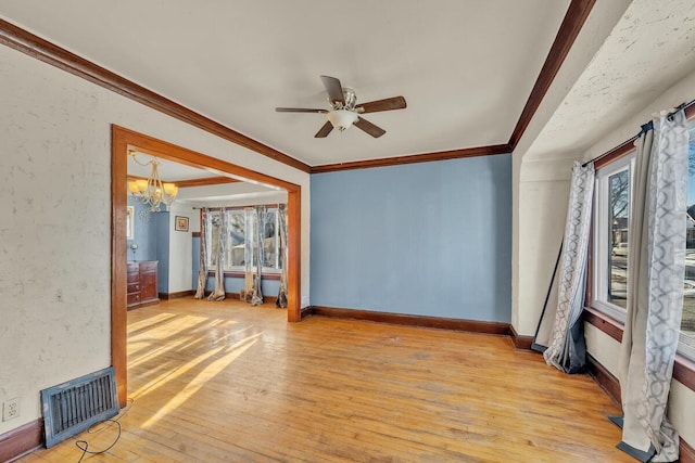 empty room with ceiling fan with notable chandelier, light hardwood / wood-style flooring, and ornamental molding