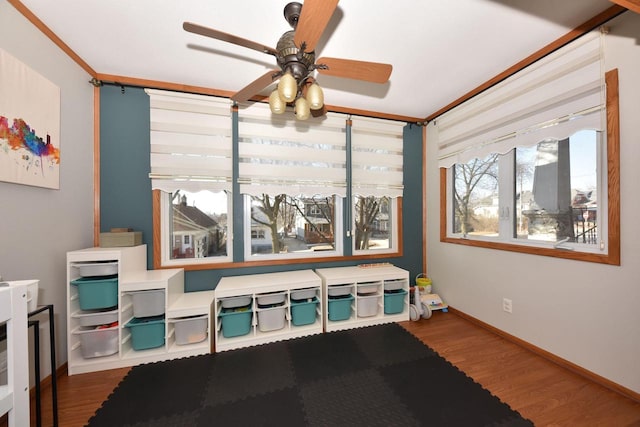 game room featuring hardwood / wood-style flooring, crown molding, and ceiling fan