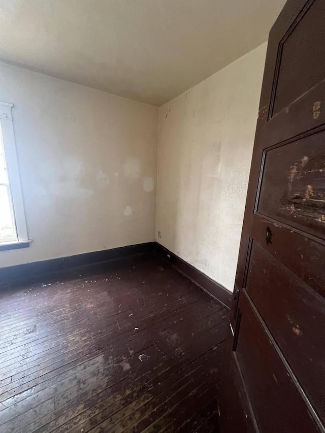 spare room with dark wood-type flooring