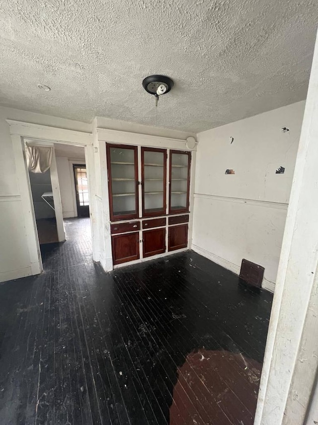 interior space with dark wood-type flooring and a textured ceiling