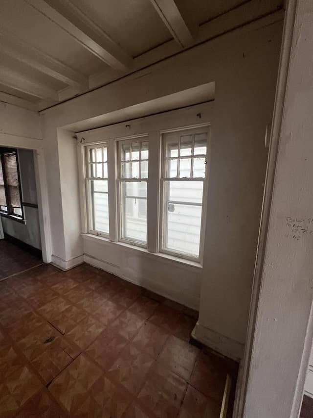 unfurnished sunroom with beam ceiling