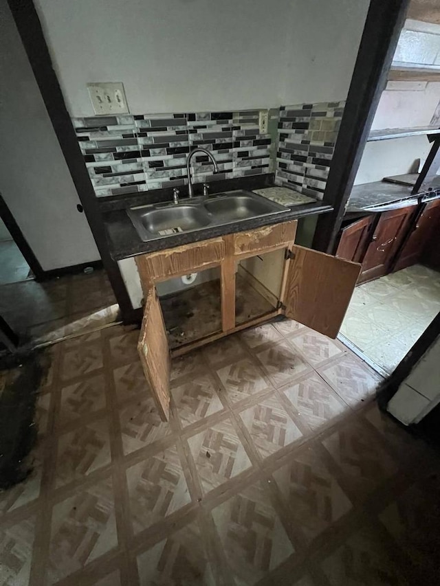 bathroom featuring parquet flooring, sink, and backsplash