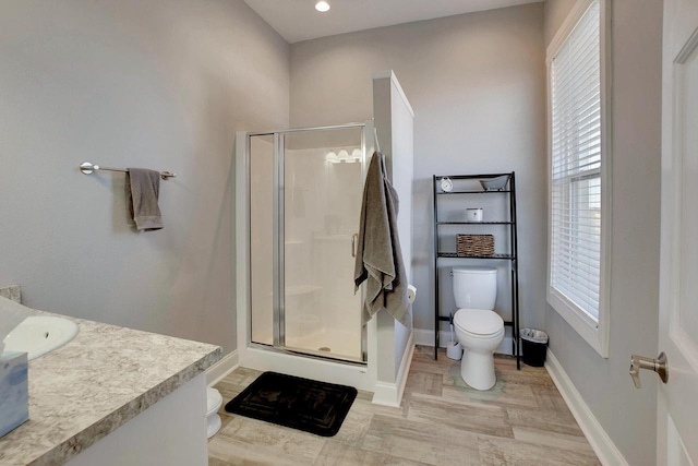 bathroom featuring hardwood / wood-style flooring, vanity, toilet, and a shower with door