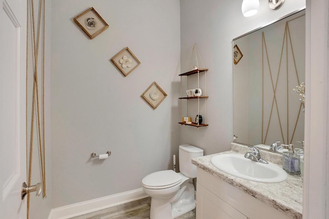 bathroom with hardwood / wood-style flooring, vanity, and toilet