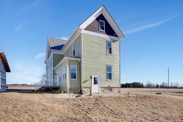 back of property featuring a yard and a rural view