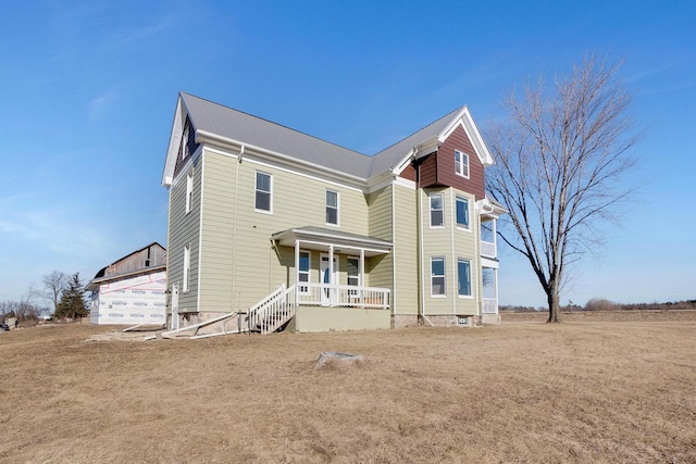 back of house with a porch and a yard