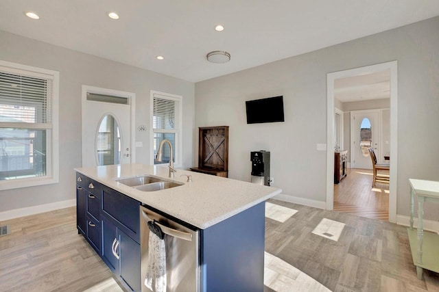 kitchen with dishwasher, sink, blue cabinetry, a center island with sink, and light hardwood / wood-style flooring