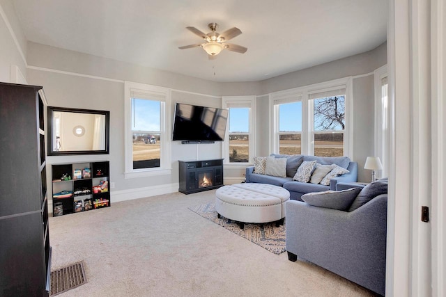 living room with carpet flooring, a wealth of natural light, and ceiling fan