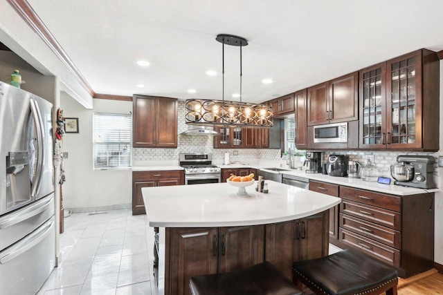 kitchen featuring a breakfast bar, tasteful backsplash, decorative light fixtures, a center island, and stainless steel appliances