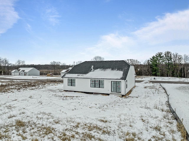 view of snow covered rear of property