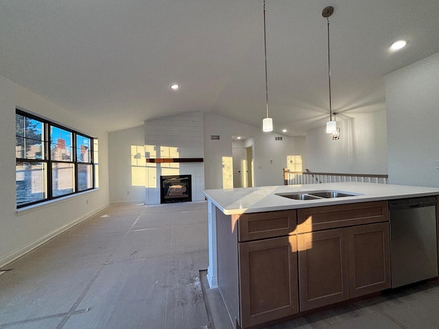 kitchen with pendant lighting, sink, dishwasher, a kitchen island with sink, and vaulted ceiling