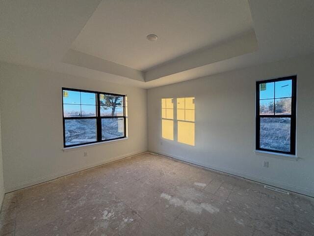 empty room with visible vents and a tray ceiling