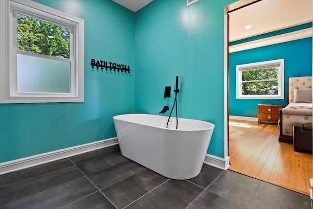 4922 W Dean Rd, Milwaukee, WI 53223 - bathroom with baseboards, plenty of natural light, a freestanding tub, and tile patterned flooring