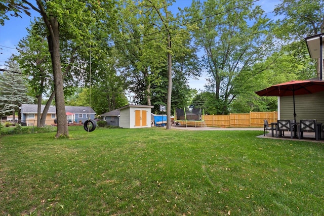 4922 W Dean Rd, Milwaukee, WI 53223 - view of yard featuring a trampoline, a storage shed, an outbuilding, a patio, and view of wooded area