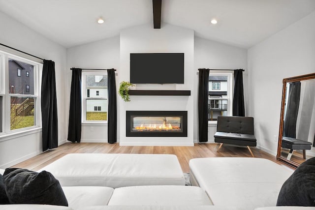 living room featuring vaulted ceiling with beams and light wood-type flooring