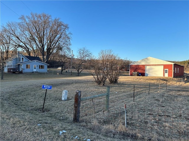 view of yard with a rural view, a garage, and an outdoor structure