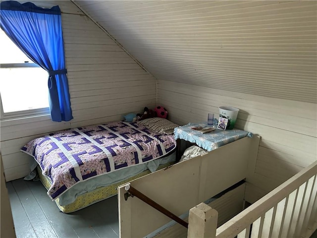 bedroom with hardwood / wood-style flooring, lofted ceiling, and wooden walls