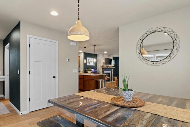 dining space with a large fireplace and light wood-type flooring