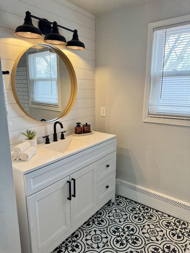 bathroom featuring baseboard heating, tile patterned floors, wooden walls, and vanity