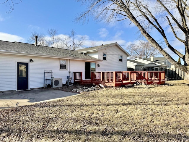 rear view of property featuring ac unit, a lawn, a deck, and a patio area