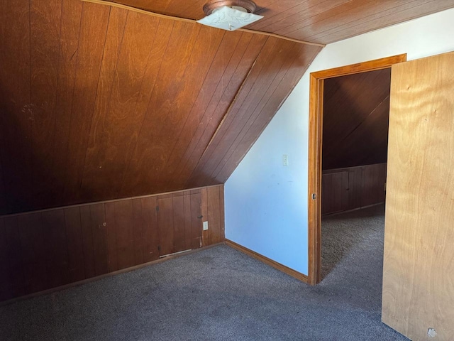 additional living space with wooden ceiling, vaulted ceiling, carpet, and wood walls