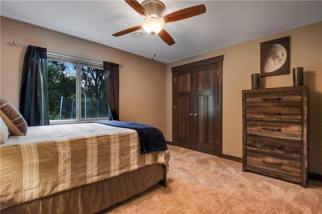 bedroom with ceiling fan and light carpet