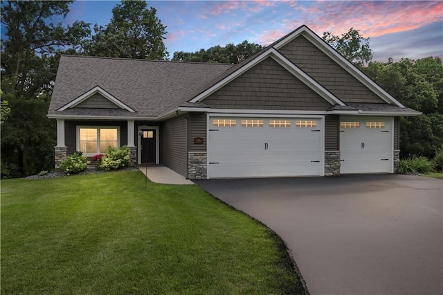 craftsman-style home with a garage and a yard