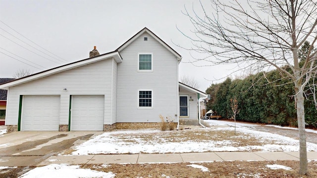 snow covered house with a garage