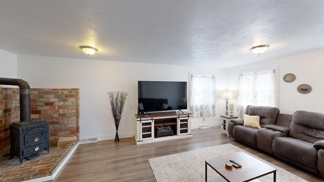 living room with wood-type flooring and a wood stove