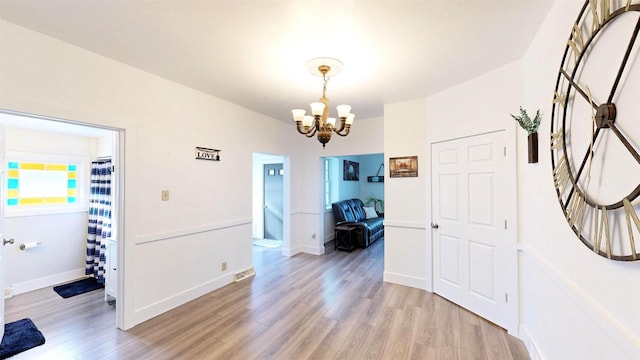 interior space with a chandelier and light hardwood / wood-style floors