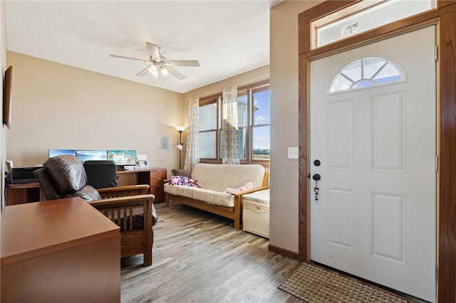 foyer entrance with ceiling fan and light wood-type flooring