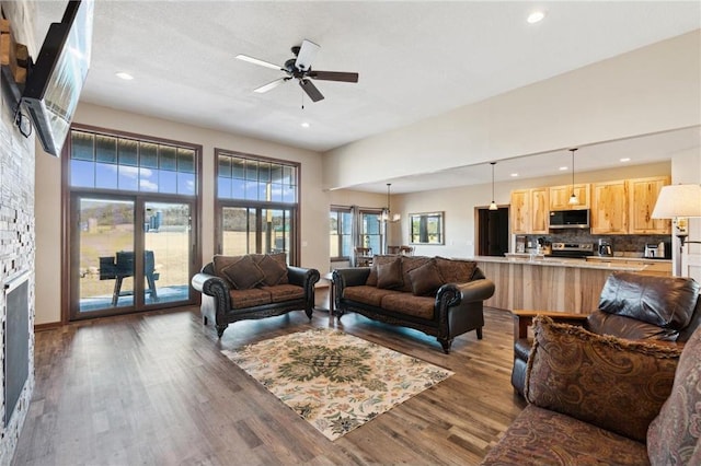 living room with dark hardwood / wood-style flooring, a fireplace, and ceiling fan