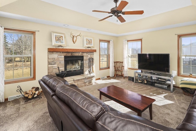 living room featuring ceiling fan, plenty of natural light, a fireplace, and carpet floors