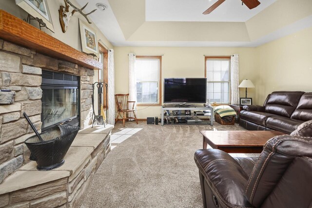 living room with a fireplace, a tray ceiling, and a wealth of natural light