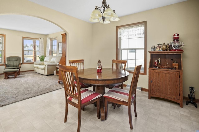 dining space with an inviting chandelier and light carpet