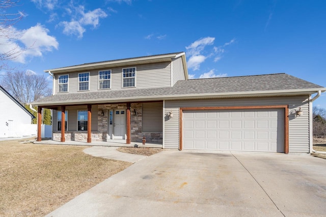 view of front of house with a garage, a front yard, and covered porch