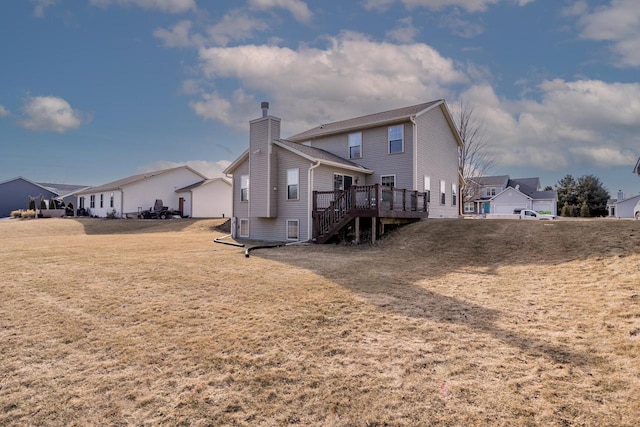 rear view of house featuring a wooden deck and a yard