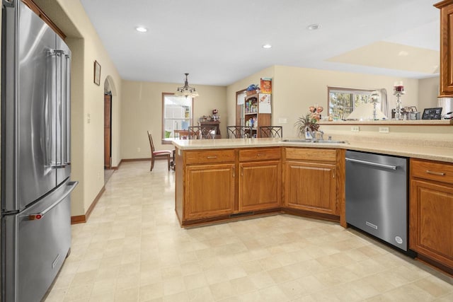 kitchen with a healthy amount of sunlight, appliances with stainless steel finishes, sink, and decorative light fixtures