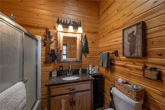 W268 County Highway A, Stone Lake, WI 54876 - full bathroom featuring vanity, wood walls, shower / bath combination with glass door, and toilet