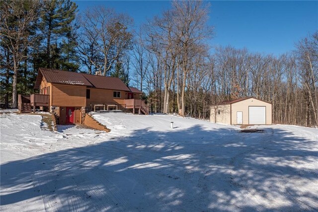 W268 County Highway A, Stone Lake, WI 54876 - yard layered in snow with a garage, a wooden deck, and an outbuilding