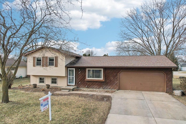 tri-level home with a garage and a front yard